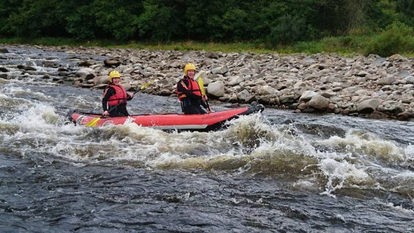 Two rowers near rapids