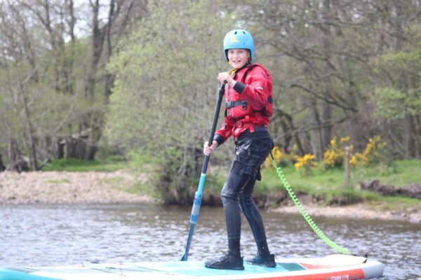 Stand up paddleboarding happy kid