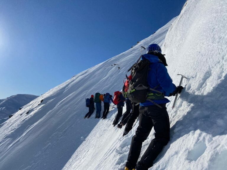 A group of people taking part in Winter Mountain Skills training in the Cairngorms, Scotland with Active Outdoor Pursuits.