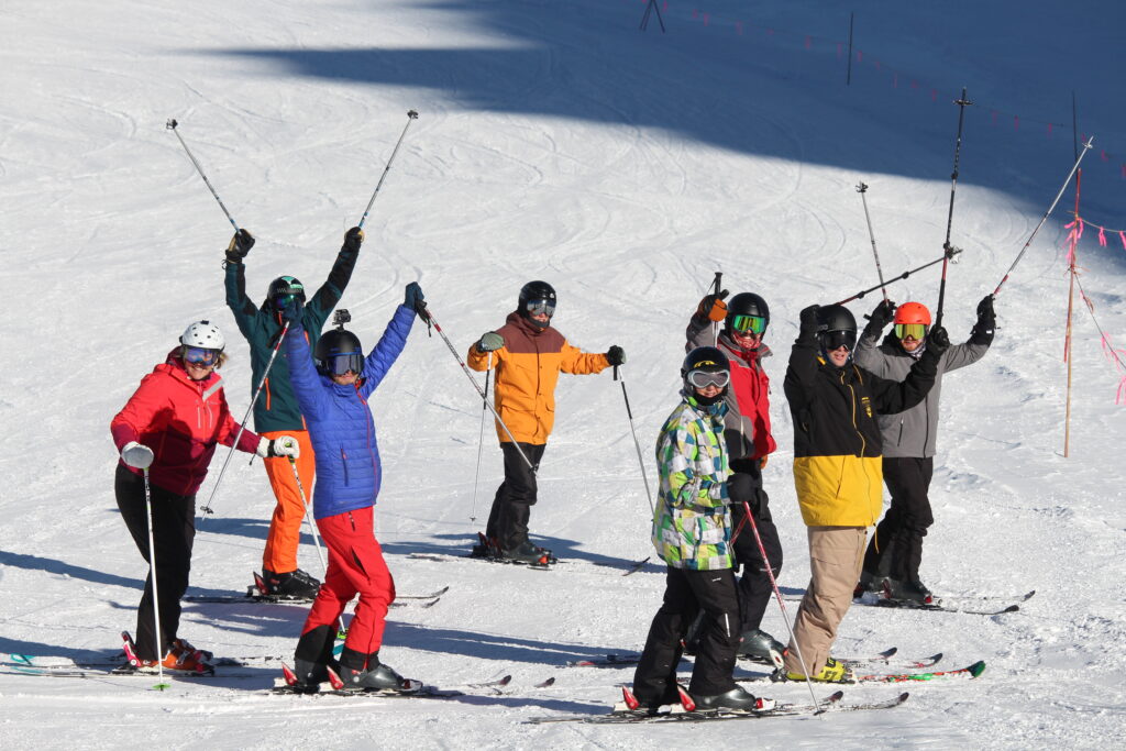 A group of people celebrating during a skiing lesson in Scotland with Active Outdoor Pursuits