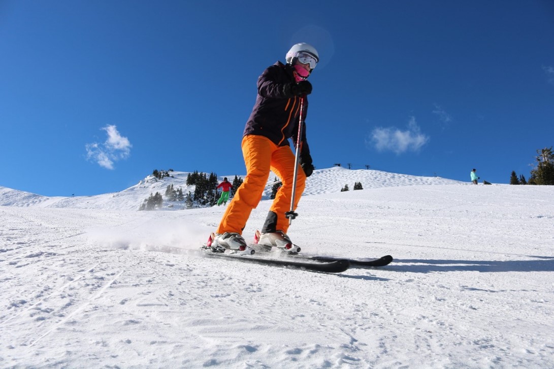 An image of someone wearing ski gear while skiing in Scotland on a sunny day.
