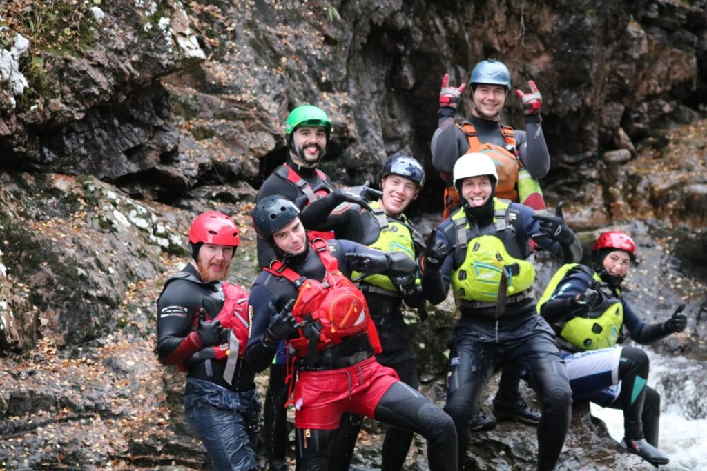 a group of people posing funnily for the camera while they canyon in Scotland.